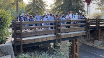 Students pose for a picture standing at a bridge 