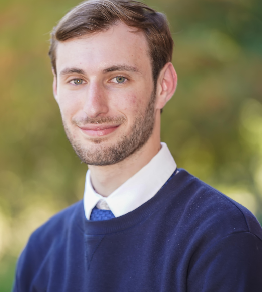 Photo of Jason, pre-law student advisor wearing a blue sweater and white collar